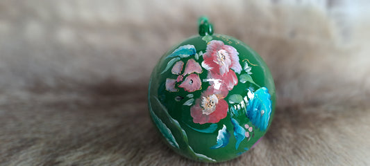 Handbeschilderde groene kerstbal met bloemen