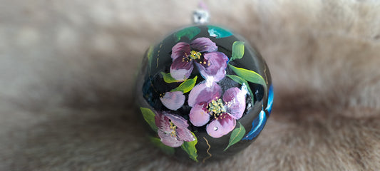 Zwarte kerstbal met paarse bloemen